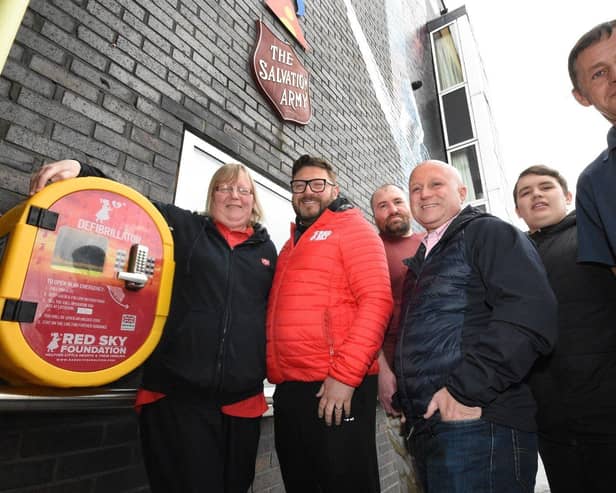 Salvation Army Chaplin Julie Judson accepts the gift of a defibrillator from Sergio Petrucci from the Red Sky Foundation watched by Swan House resident Steve Rodgers; Gerard May , Cameron Hirst from the Red Sky Foundation and Keith Reay, concierge at Swan Lodge.