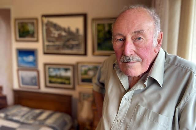 Clive Madgin with just a few of the hundreds of paintings he has created.