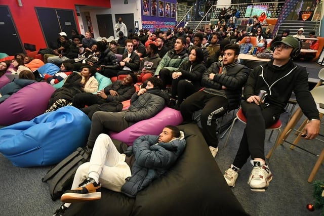 Students gathered in the City Space, engrossed in the match.