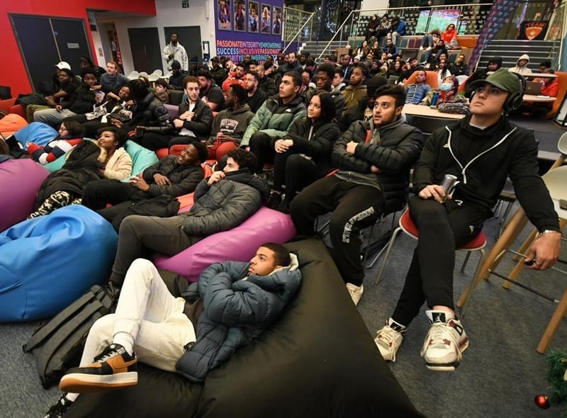 Students gathered in the City Space, engrossed in the match.