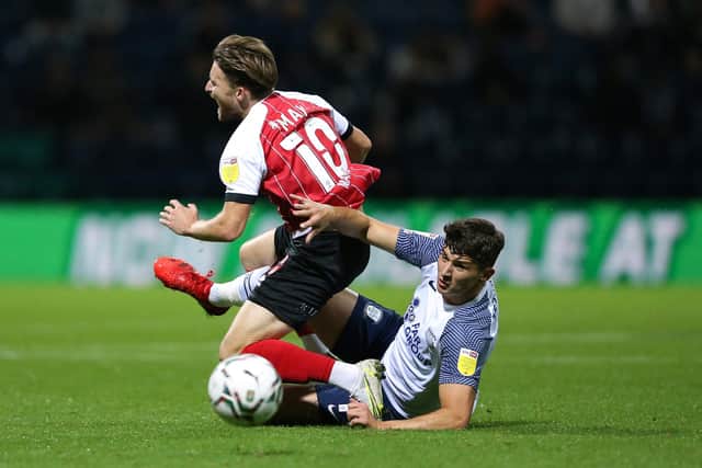 PRESTON, ENGLAND - SEPTEMBER 21: Alfie May of Cheltenham Town is fouled by Jordan Storey of Preston North End during the Carabao Cup Third Round match between Preston North End and Cheltenham Town at Deepdale Stadium on September 21, 2021 in Preston, England. (Photo by Charlotte Tattersall/Getty Images)