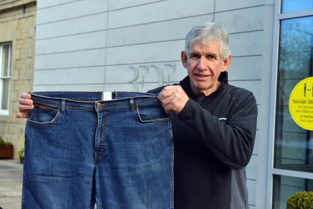 Geoff Forster with a pair of the jeans he used to wear before losing nearly seven stone.