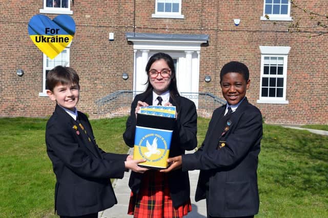 Southmoor Academy students Otis Arkley, 12, Isabella Raymond, 12 and Femi Aisida, 12, with their Peace in Ukraine collection bucket for the Ukraine Disaster Emergancy Committee.