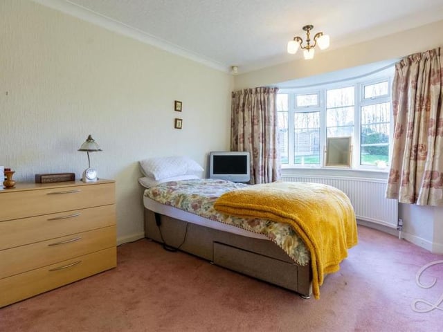 We're moving across the inner hallway now to find the largest bedroom. A comfortable space, it boasts a carpeted floor, a central heating radiator and a grand bay window to the front of the property.
