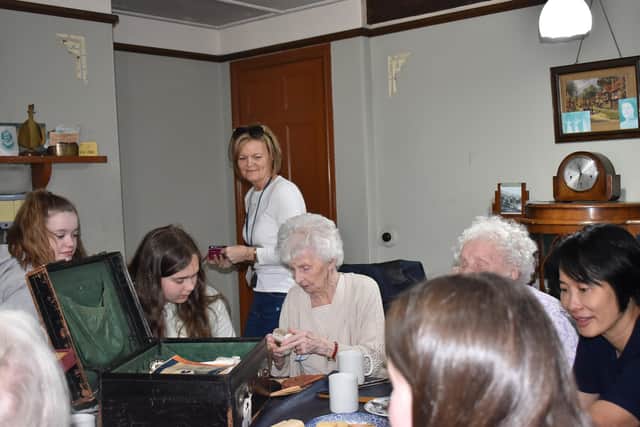 Children and some of the older people looking at the memory box in Orchard Cottage at Beamish Museum.