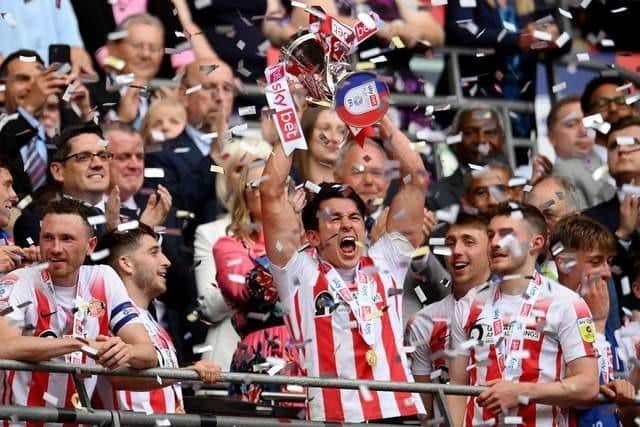 Luke O'Nien lifting the League One play-off trophy at Wembley.
