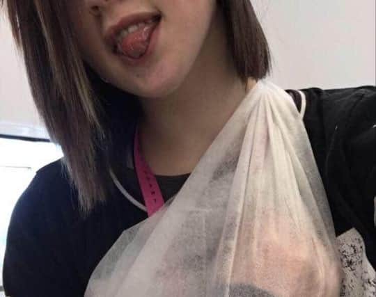 Evie with her arm in a sling when she was paralysed and her arm turned purple.