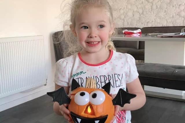 Three year-old Katie Black with one of the beautiful baby pumpkins she created, which were later taken from outside her home