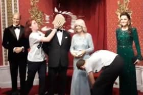 Screen grab taken from a handout video issued by Just Stop Oil of two activists throwing chocolate cake on a waxwork model of King Charles III at Madam Tussauds in London. Credit: Just Stop Oil/PA Wire