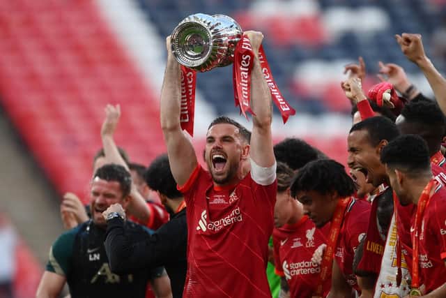 LONDON, ENGLAND - MAY 14: Jordan Henderson of Liverpool lifts The Emirates FA Cup trophy after their sides victory during The FA Cup Final match between Chelsea and Liverpool at Wembley Stadium on May 14, 2022 in London, England. (Photo by Mike Hewitt/Getty Images)