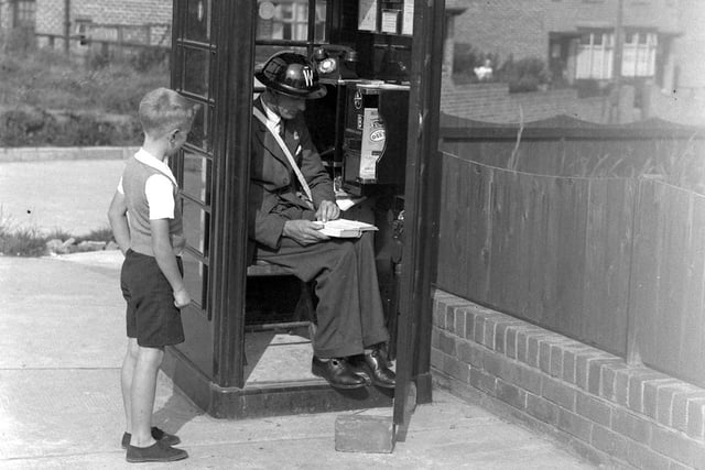 An air raid warden takes up position in a telephone kiosk in Sunderland in 1939.