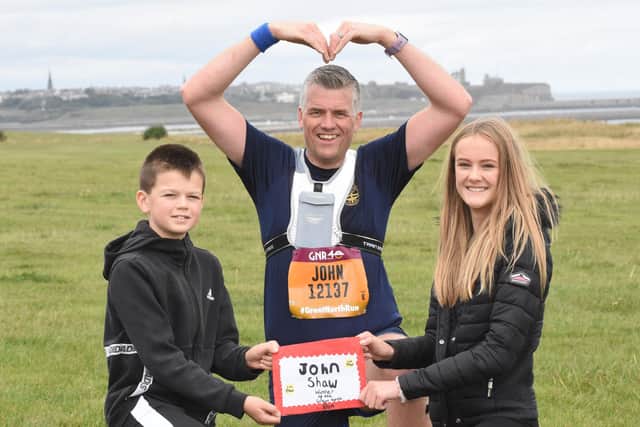 John was awarded a certificate for finishing the Great North Run at South Shields by his children William and Robyn.