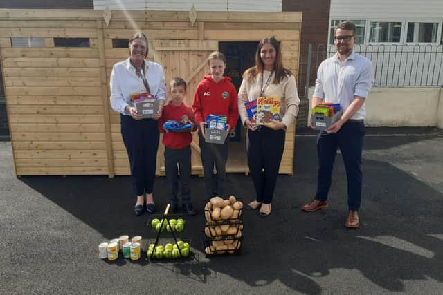 (left to right) Teaching assistant Karen Quill, William Hartwell, 11, Amelia Cooney, 11, headteacher Lesley Cassidy and Cllr Richard Dunn outside the school's new food bank.