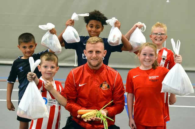 Foundation of Light head of Football in the Community, David Dowson , showing some of the free ingredients provided to children as part of the charity's holiday hunger initiative.
