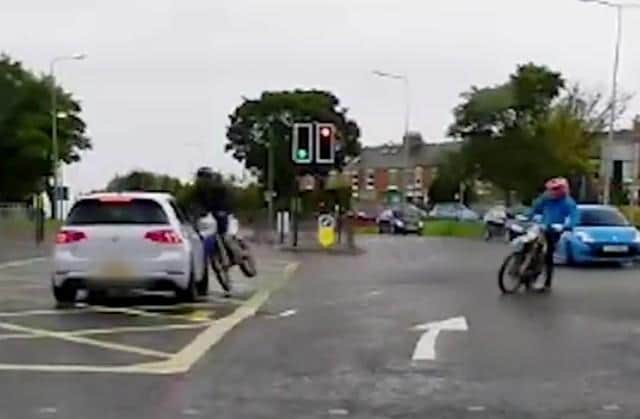 A still from the collision footage shows the moment the biker slams into the car.