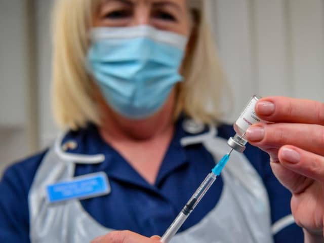 A practice nurse draws off a single dose from a vial of the Oxford University/AstraZeneca COVID-19 vaccine.