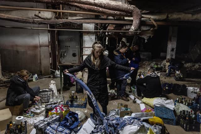 A volunteer helps to make molotov cocktails in the basement of a bomb shelter on February 26, 2022 in Kyiv, Ukraine. (Photo by Chris McGrath/Getty Images)