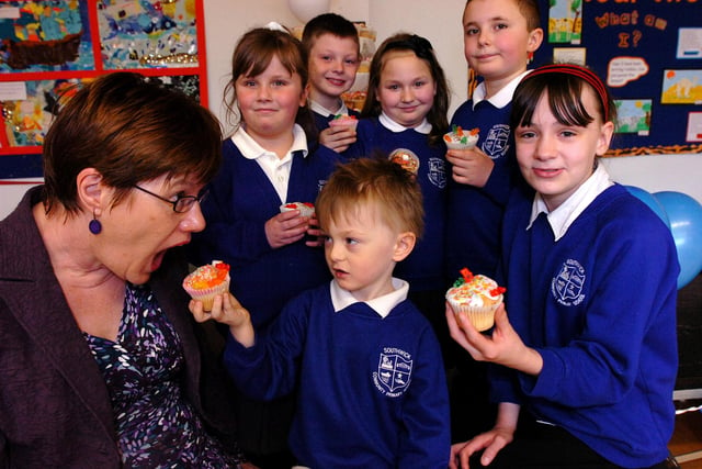Chair of the Governors Sue Adshead takes a bite from one of the 400 cupcakes which were baked to celebrate the school's birthday in 2010.