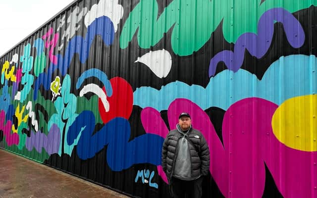 Artist Mul Draws with one of his murals at Dalton Park