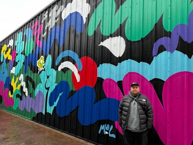 Artist Mul Draws with one of his murals at Dalton Park