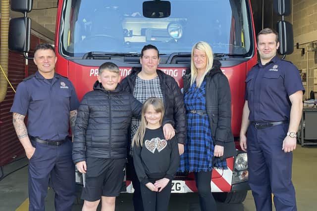 Olivia with mum Samantha, Auntie Kayley, brother Alfie, and TWFRS firefighters.
