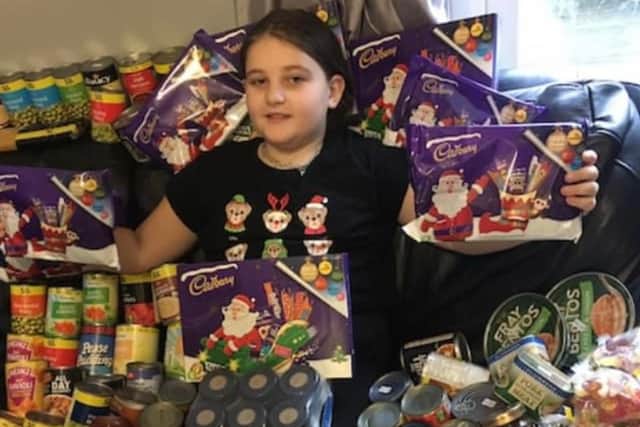 Gabriella Bland, nine, with some of the food she donated to struggling families
