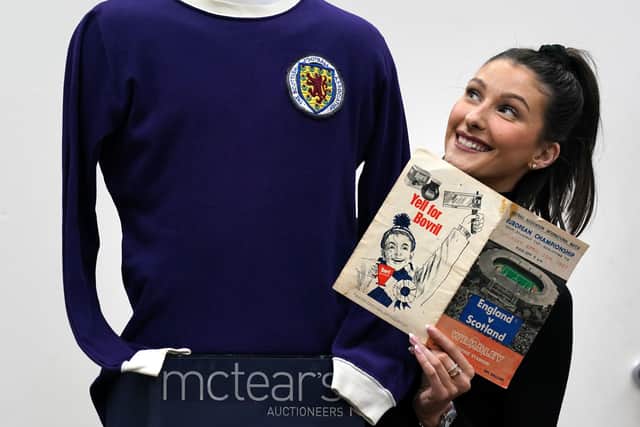 Auctioneer Amy Cameron with Jim Baxter's match worn jersey from Scotland's 3-2 win over then world champions, England, at Wembley in 1967.