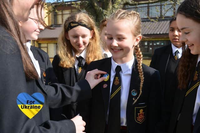 Pupils receiving their Peace in Ukraine stickers after making a donation.