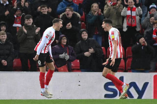 SUNDERLAND, ENGLAND - DECEMBER 11: Sunderland player Dan Neil (l) celebrates with Ross Stewart after scoring the opening goal during the Sky Bet League One match between Sunderland and Plymouth Argyle at Stadium of Light on December 11, 2021 in Sunderland, England. (Photo by Stu Forster/Getty Images)