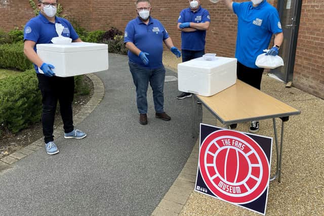 Manchester United U23 goalkeeper Paul Woolston, right, with Fans' Museum volunteers, left to right, Andy Parkin, David Barker and Michael Ganley with food that they are setting off to deliver. Picture by Frank Reid.