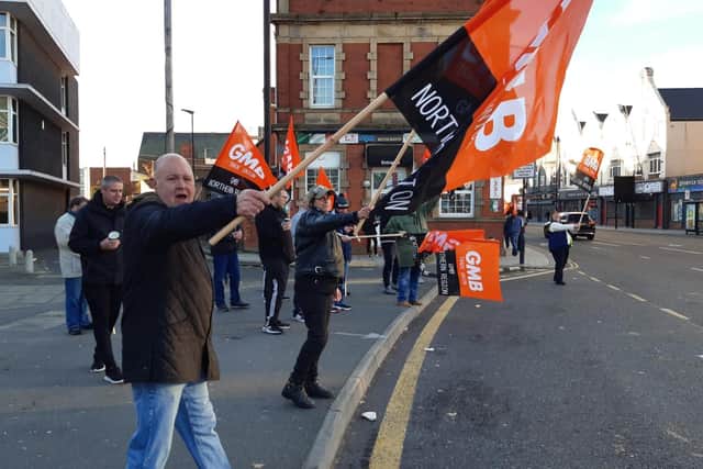 Pickets wave flags for passing motorists