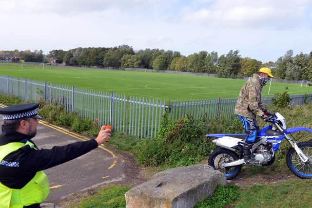 A picture posed by Northumbria Police of an officer tackling a problem rider.