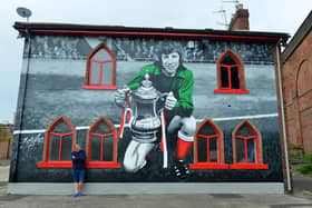 The Times Inn landlord Steve Lawson admires the finished Jimmy Montgomery mural by Frank Styles on the side of his pub. 