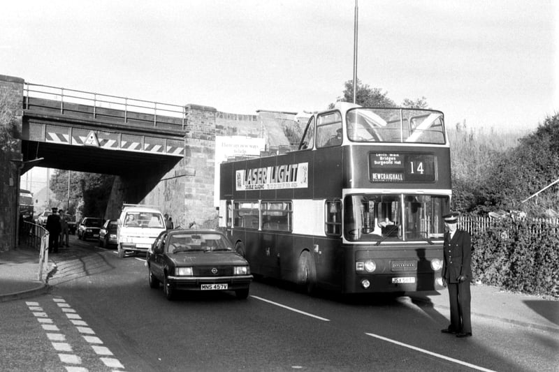 A policeman stands beside a no 14 Lothian Region Transport bus which had its roof ripped off passing under a low bridge at Newcraighall Road in Edinburgh, September 1986.