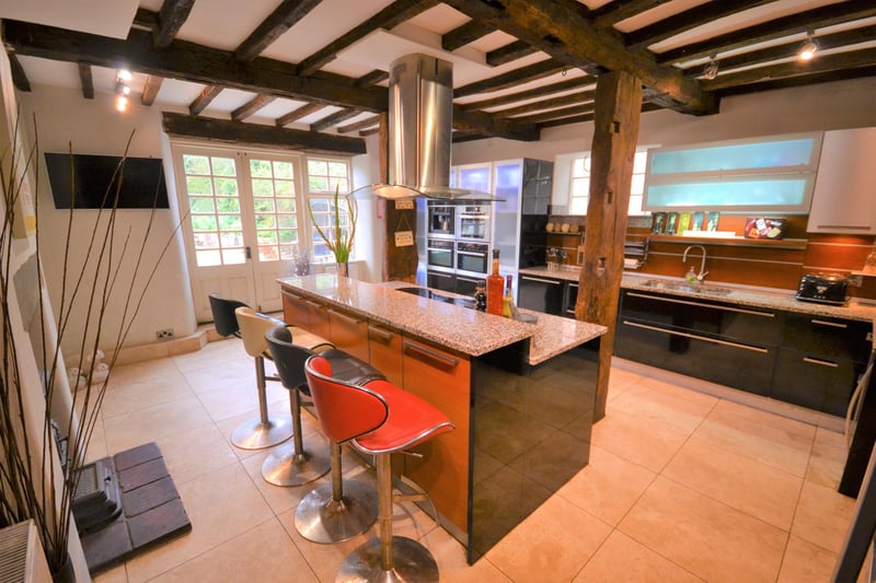 A spacious breakfast kitchen with French doors opening to a patio seating area.