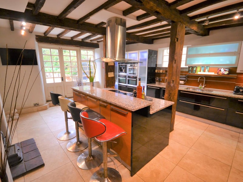 A spacious breakfast kitchen with French doors opening to a patio seating area.