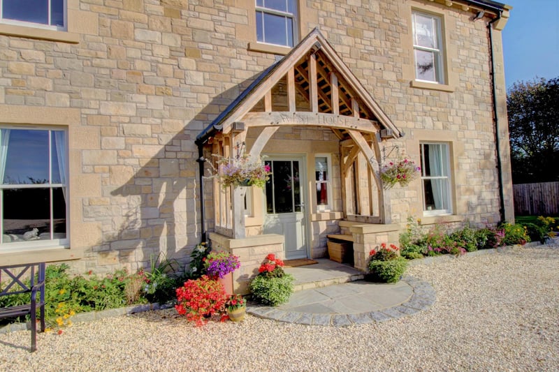 This charming family home is entered through an exterior oak covered porch with stone slab paving leading to the front door.