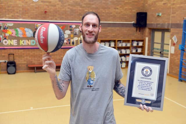 Former Harlem Globetrotters basketball player, Paul Sturgess, with his certificate from the the World Guinness Records officially recognising him as the world's tallest basketball player.