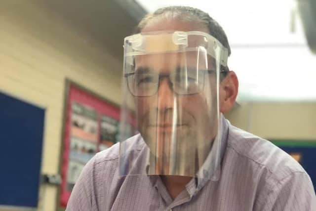 Headteacher Ian Redford modelling the reusable face shields that the school is producing.