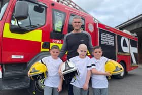 Peter Wilson with his nephews Oscar, Oliver and Owen outside of Sunderland Central Community Fire Station.