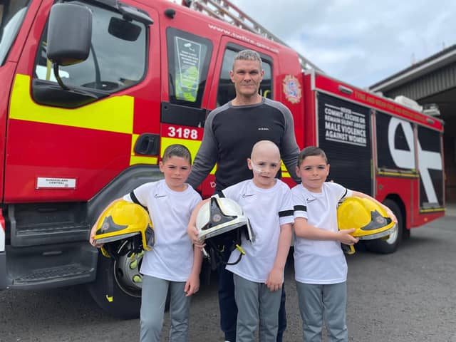 Peter Wilson with his nephews Oscar, Oliver and Owen outside of Sunderland Central Community Fire Station.