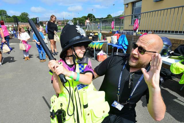 Seth Bray, six, dresses as a police officer at the Summer Bus event as Police officer Jim Gordon looks on. 

Picture by Frank Reid