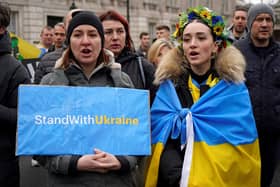 People hold placards during a rally in support of Ukraine, in near Downing Street on Whitehall in central London on March 13, 2022, following the invasion of the country by Russia. - Stung by criticism of its lacklustre approach to refugees fleeing Russia's invasion of Ukraine, the UK on Sunday unveiled a new scheme to allow them to stay with Britons for up to three years. (Photo by Niklas HALLE'N / AFP) (Photo by NIKLAS HALLE'N/AFP via Getty Images)