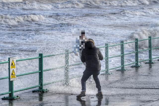 Pair take pictures as waves hit sea walls Picture by North News