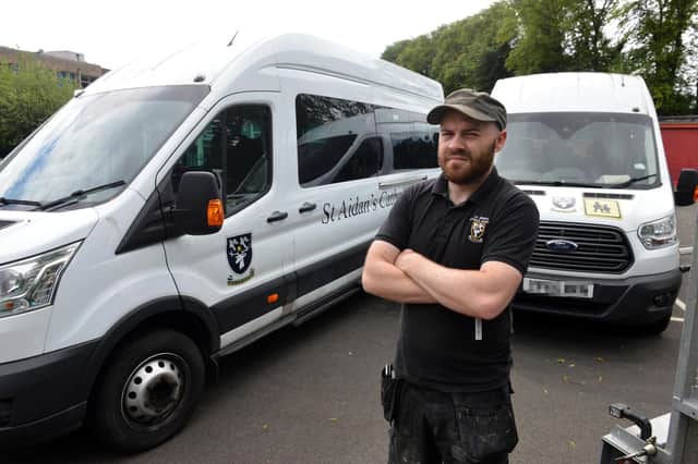 St Aidan's Catholic Academy caretaker Andy Kennerley with the mini buses that were damaged in an attempted theft.