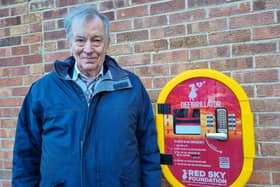 Cllr Paul Gibson with the defibrillator at the entrance to the park.