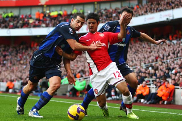 Carlos Vela of Arsenal is challenged by Tal Ben-Haim and Steed Malbranque of Sunderland during the Barclays Premier League match between Arsenal and Sunderland at Emirates Stadium.