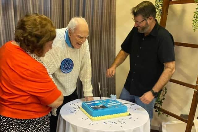 Tom cuts the cake on his 100th birthday.
