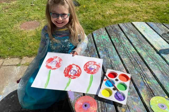 Izzy Macrae with the poppy circles she has made for the VE Day commemoration.