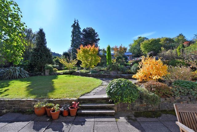 The beautifully kept and enclosed south facing garden has a paved patio, established borders, lawns, trees and a pond with water feature.